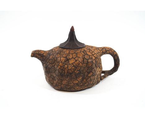 A Chinese earthenware teapot and cover, with scale-like pattern all-over, stamped to underside, 12cm high, a Japanese pewter 