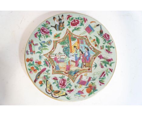 A Canton enamel plate with celadon glaze, the hand painted central panels depicting figures within an interior, surrounded by