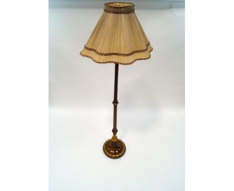 An ornate mahogany standard lamp, the reeded column with carved acanthus leaf sections and leaf surround to the base,  with p