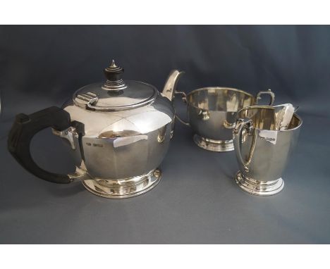 A silver three piece tea service, maker F.C. Sheffield 1935, of round panelled form, 962 g (31 troy ozs) gross