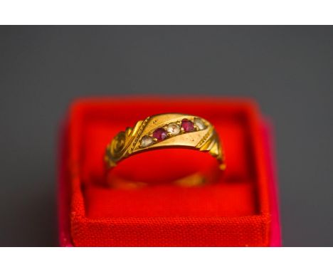 An 18ct gold ruby and rose cut diamond ring, the alternate set line to a carved head mount, finger size P1/2, 3.5 g gross