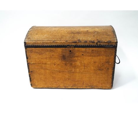 A pine trunk with dome top and iron handles, formerly leather covered, with some brass studs remaining, 63cm high x 93cm wide