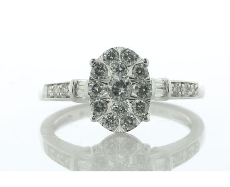 Thirteen round brilliant cut diamonds are set in oval shaped cluster to create an illusion of a large oval centre stone. On e