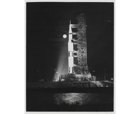 
	
		Saturn rocket stands ready on the launch pad with the Moon shining next to it
		Apollo 17, November 1972
		Vintage gelat