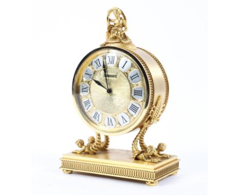 A Luxor French gilt mantel clock of circular form surmounted by classical figurine the silver and gilt dial with Roman numera