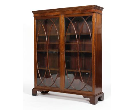 A George III style mahogany glazed bookcase, with two doors with ovolo-shaped astragals, enclosing three shelves, on ogee bra