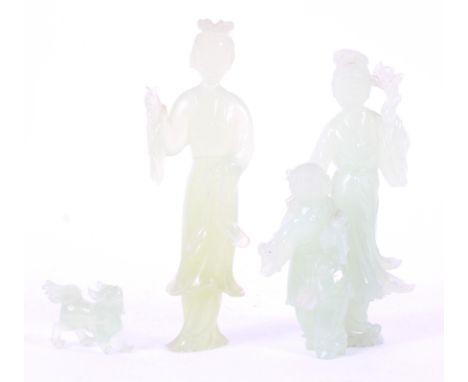 Two Chinese carved celadon jade-type figures and a lion dog, 20th century, comprising: a mother and child, another figure in 