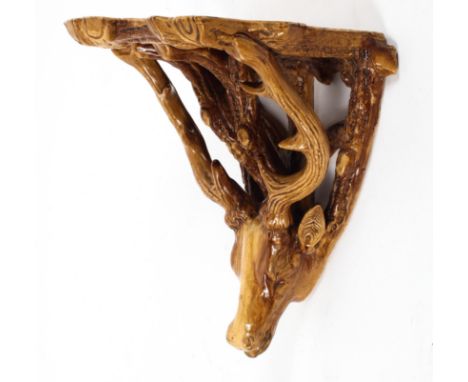 A 19th century pottery stag-shaped wall bracket, late 19th century, modeled as a stag's head supporting a shelf, enriched in 