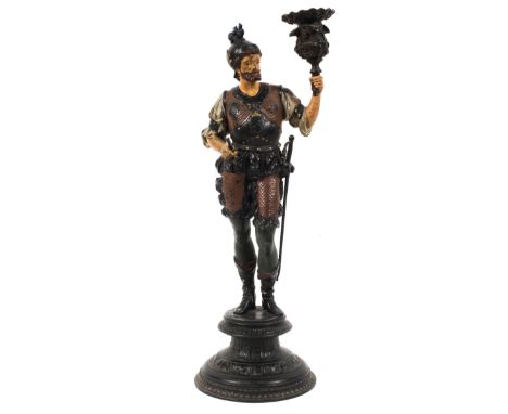 A 19th century spelter figural candlestick, cast as a standing soldier holding a foliate nozzle, cold painted in colours, on 
