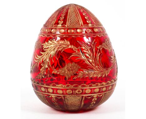 A Faberge (St Petersburg) cut glass gilt ruby egg, 20th century, blue label to underside, cut and gilt with swags of berried 