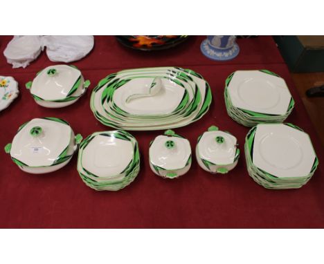 A Wedgwood green and black decorated Art Deco design part dinner service, comprising graduated meat plates, four tureens, lad