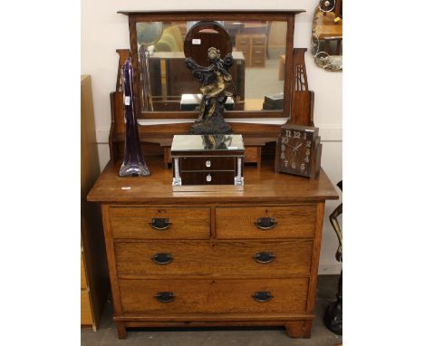 An oak Art Deco design dressing chest, with raised mirrored back fitted with a trinket drawer, two short and three long drawe