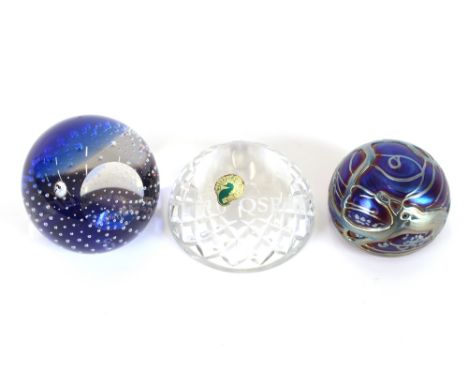 A Waterford glass paperweight; a blue glass paperweight by Caithness; and another Loetz style similar