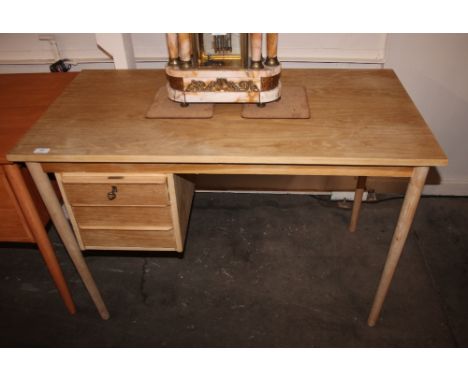 A Danish light oak single pedestal writing desk, fitted three drawers raised on rounded tapering supports, 111cm wide