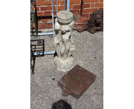 A stone bird bath base with vintage metal weight
