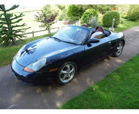 A 1998 Porsche Boxster, registration number R315 JPF, blue.  This early Boxster has a manual gearbox, a red leather interior 