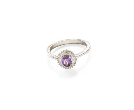 An 18 Carat White Gold Purple Sapphire and Diamond Cluster Ring, by Iliana, the oval cut purple sapphire within a border of t