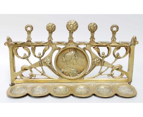 An Art Nouveau Brass Pipe Stand, cast with the profile of a maiden and mistletoe, unmarked, 30cm long, 16cm high