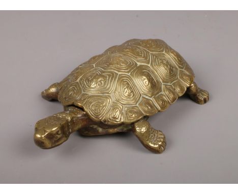 A Victorian novelty cast brass inkwell modelled as a tortoise, the hinged brass carapace opening to reveal two pot ink wells,