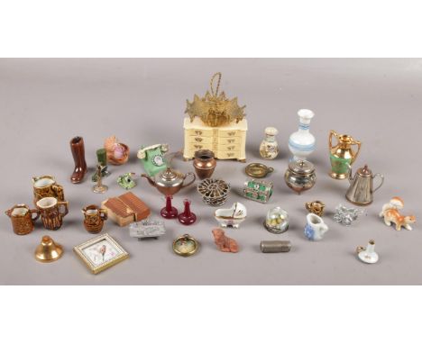 A box of dolls house miniatures including three cold painted spelter telephones, celluloid commode etc.  