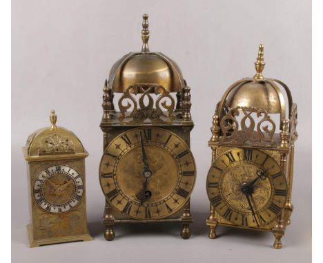 Two 17th century style brass cased lantern clocks and a similar brass cased timepiece with engraved scrollwork. Largest marke
