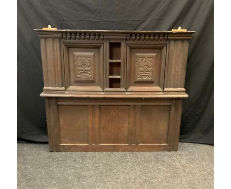 A 17th/18th century carved oak panel section, the top with central narrow three tier shelf between carved panels, above three