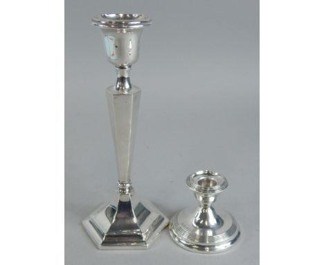 A George V silver candlestick, with a tapering column, octagonal base, Chester 1915, 20cm high, and a dwarf candlestick.