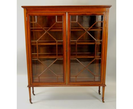 An Edwardian mahogany and satinwood crossbanded display cabinet, the top with a moulded cornice above two astragal glazed doo