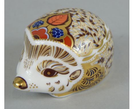 A Royal Crown Derby porcelain bramble hedgehog, printed mark in red to underside and gold button