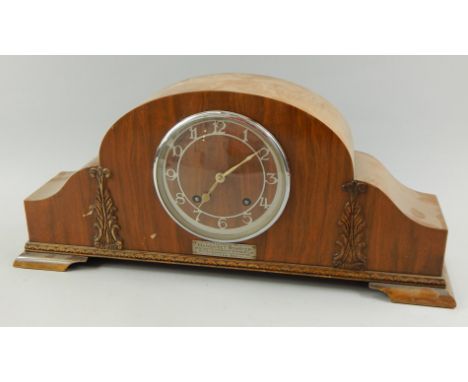 A 1950's walnut cased mantel clock, with silvered dial, bearing plaque, inscribed Presented to Margaret Bowsher by the commit