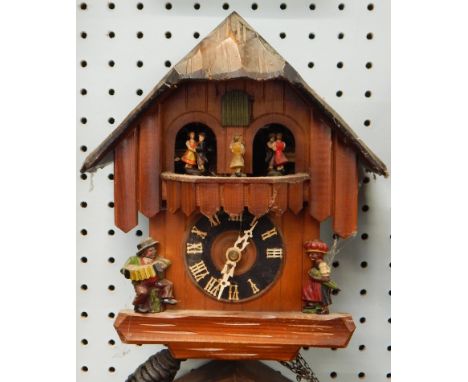 A Black Forest type cuckoo clock, carved with figures etC, 26cm high 