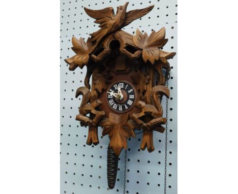 A modern German Black Forest type cuckoo clock, carved with birds, squirrels, leaves, etC