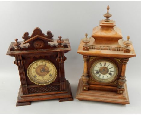 Two similar German walnut mantel clocks, each with an enamel type dial and a carved case, the tallest 44cm high