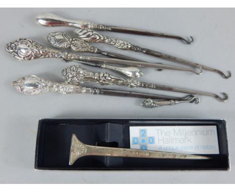 A collection of silver mounted button hooks, a millennium silver letter knife etC