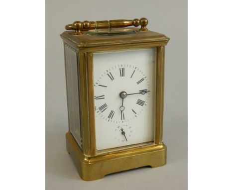 A small French brass carriage clock, the white enamel dial with Roman numerals and seconds hand, striking a bell, with alarm,