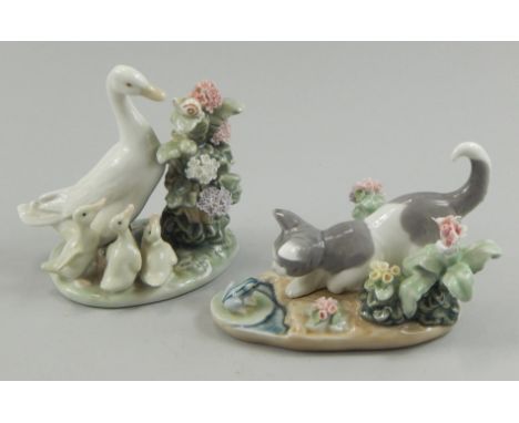 A pair of Lladro porcelain flower encrusted figures, one in the form of a kitten with a frog, the other a goose with her chic