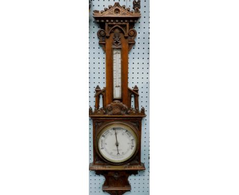 An early 20thC Gothic carved oak barometer, the dial stamped Curtis & Horspool, Leicester, 100cm high