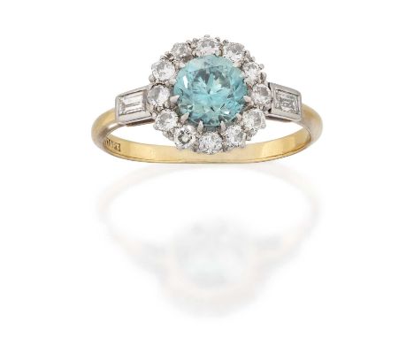 the round cut blue zircon within a border of round brilliant cut diamonds, to baguette cut diamond set shoulders, in white cl