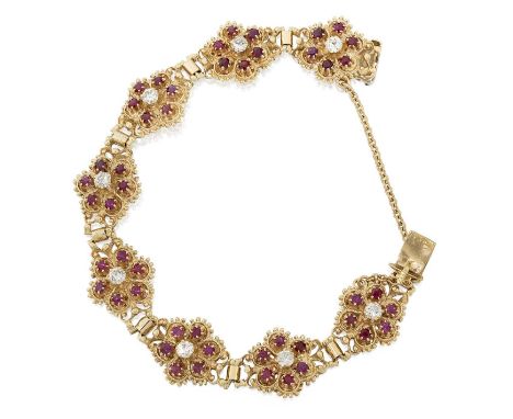 formed of eight clusters comprising of a round brilliant cut diamond within a border of round cut rubies, in yellow claw sett