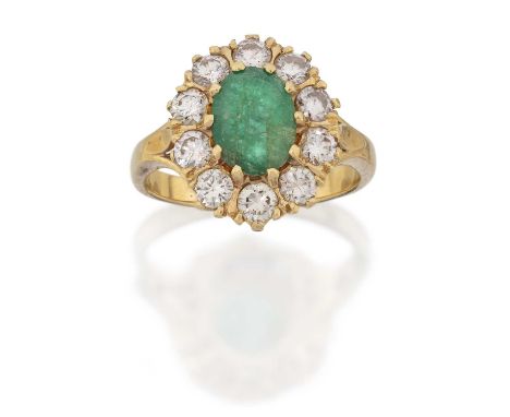 the oval cut emerald within a border of round brilliant cut diamonds, in yellow claw settings, to a tapered shoulder plain po