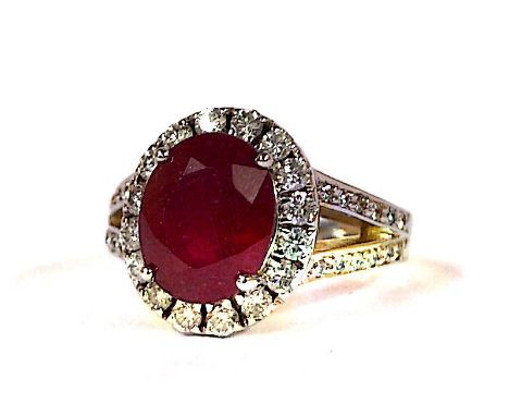 An 18ct white gold ring set with a ruby (approx 3ct) surrounded by diamonds (approx 0.5ct). R