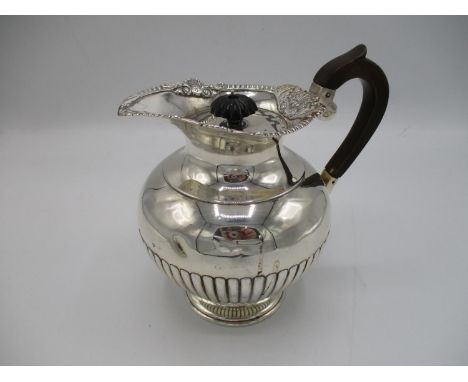 A late Victorian silver claret jug, London 1893, by Walter and John Barnard, with part fluted decoration to the body, raised 