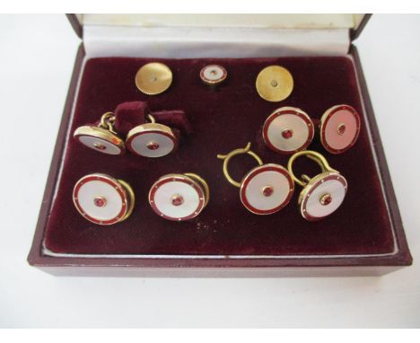 A 1980s nine piece, 9ct gold and enamelled gentleman's shirt stud set with matching cufflinks, each set with a ruby in a Haro