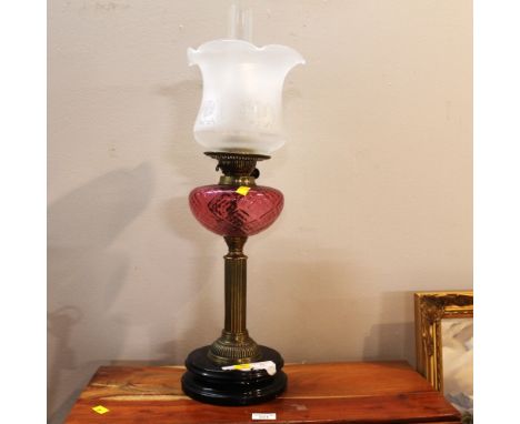 Brass column oil lamp with cranberry reservoir and etched shade, 64 cm high