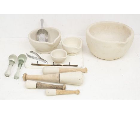A collection of chemist mortars and pestles, along with ceramic chopping board