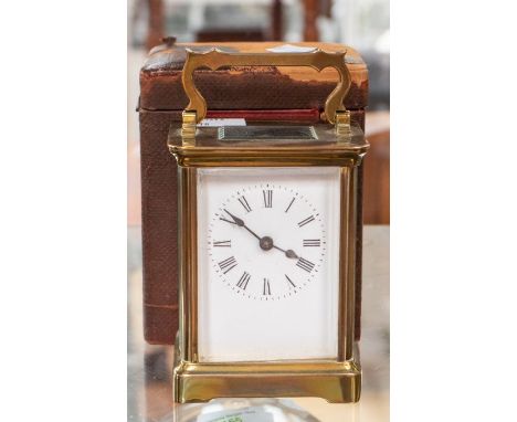 An early 20th century French gilt metal carriage clock, white enamel dial with black roman numeral to the chapter ring, a swa