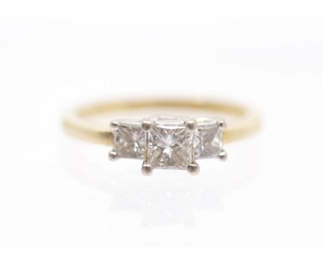 A three stone diamond and 18ct gold ring, comprising a central claw set princess cut diamond approx 0.30ct with two smaller p