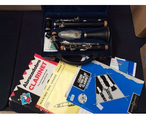 Modern Clarinet In Original Case with clarinet music books.