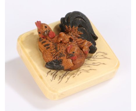 Japanese Meiji period ivory and boxwood netsuke, the carved hen with chicks above the ivory panel and signed plaque to the re