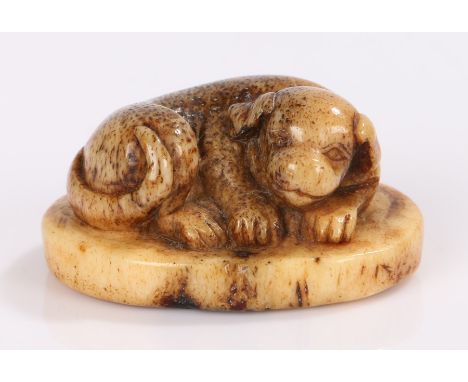 Japanese Edo period netsuke, the stag antler netsuke carved as a reclining dog, signature to the base. 4cm wide